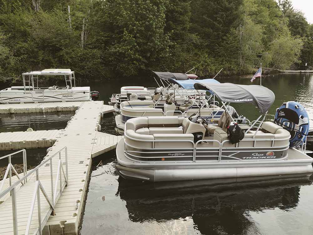 Pontoon boats at the dock at HARMONY LAKESIDE RV PARK & DELUXE CABINS