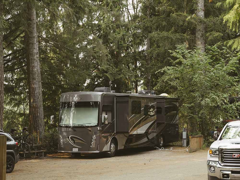 A motorhome in a wooded RV site at HARMONY LAKESIDE RV PARK & DELUXE CABINS
