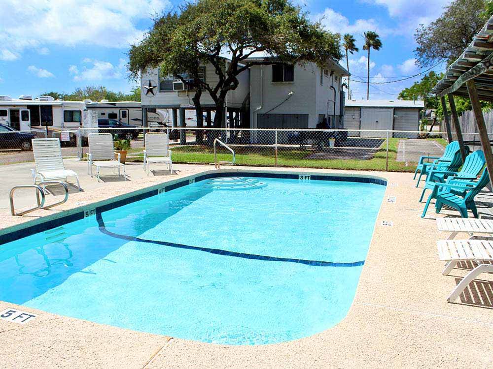 Pool with outdoor seating at PADRE PALMS RV PARK