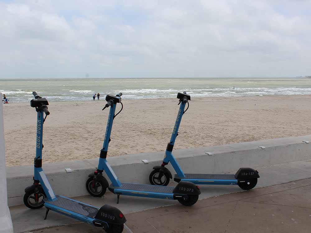 A row of rental scooters by the beach nearby at PADRE PALMS RV PARK