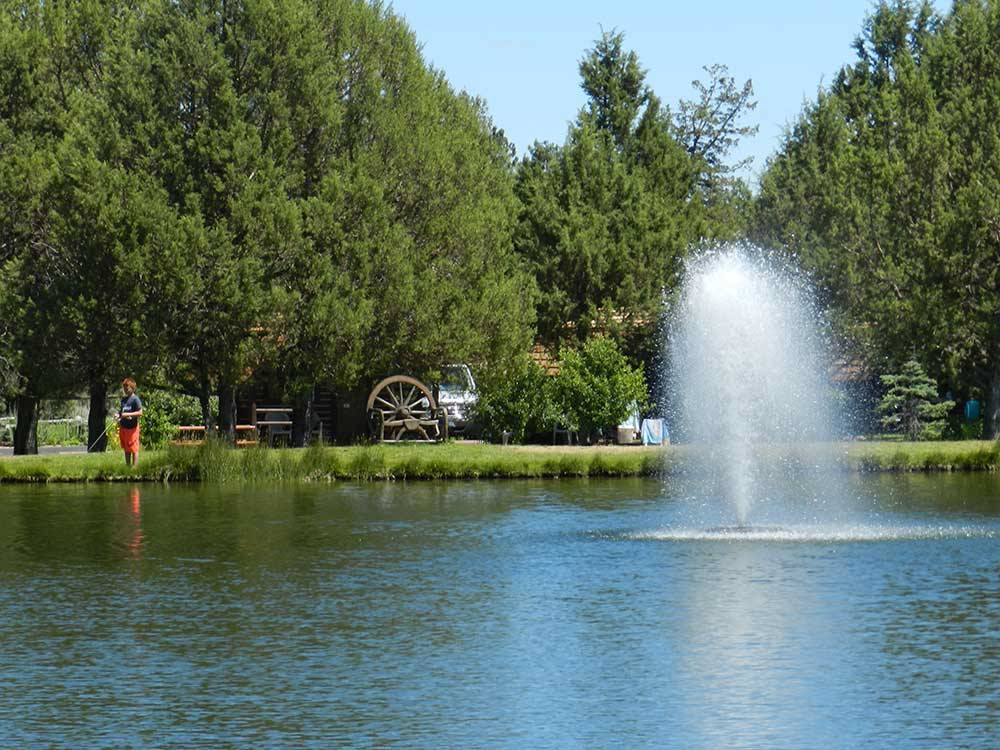 Fishing in the pond with geiser-like water feature at BEND/SISTERS GARDEN RV RESORT