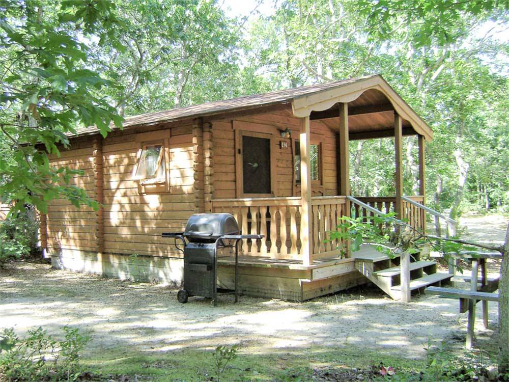 Cabin with front porch and grill outside at MARTHA'S VINEYARD FAMILY CAMPGROUND