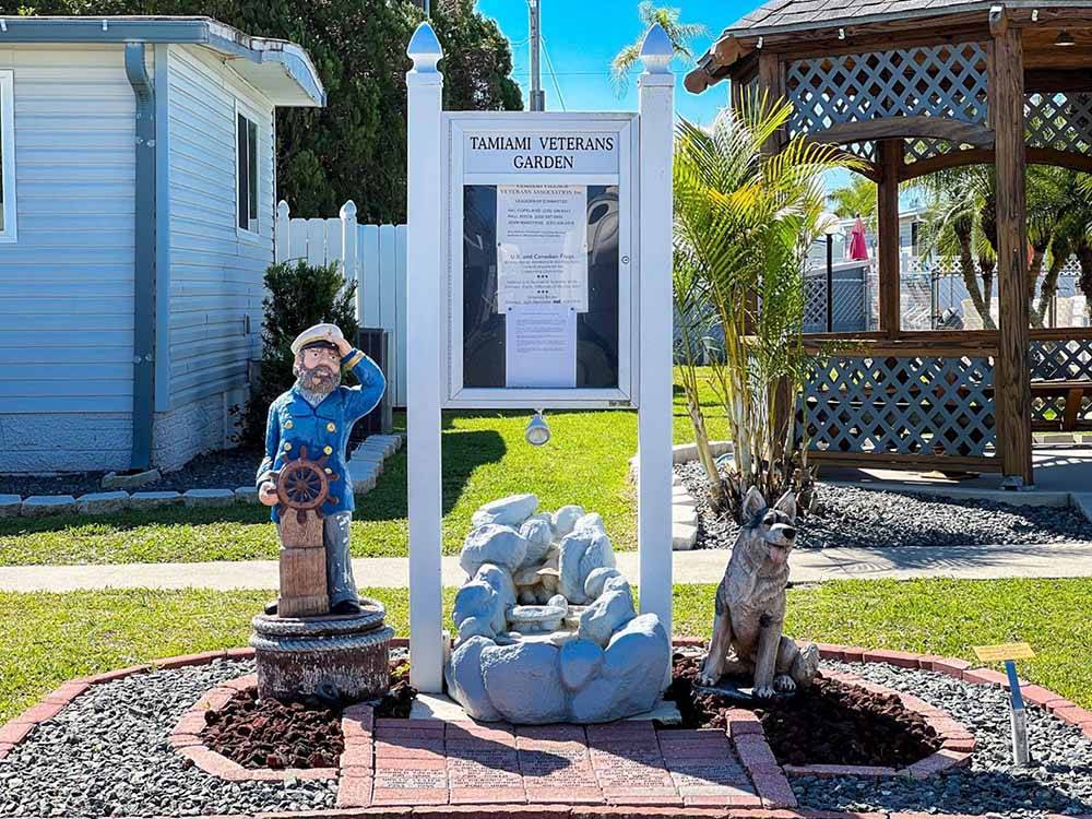 The bulletin board with statues on either side at TAMIAMI RV PARK