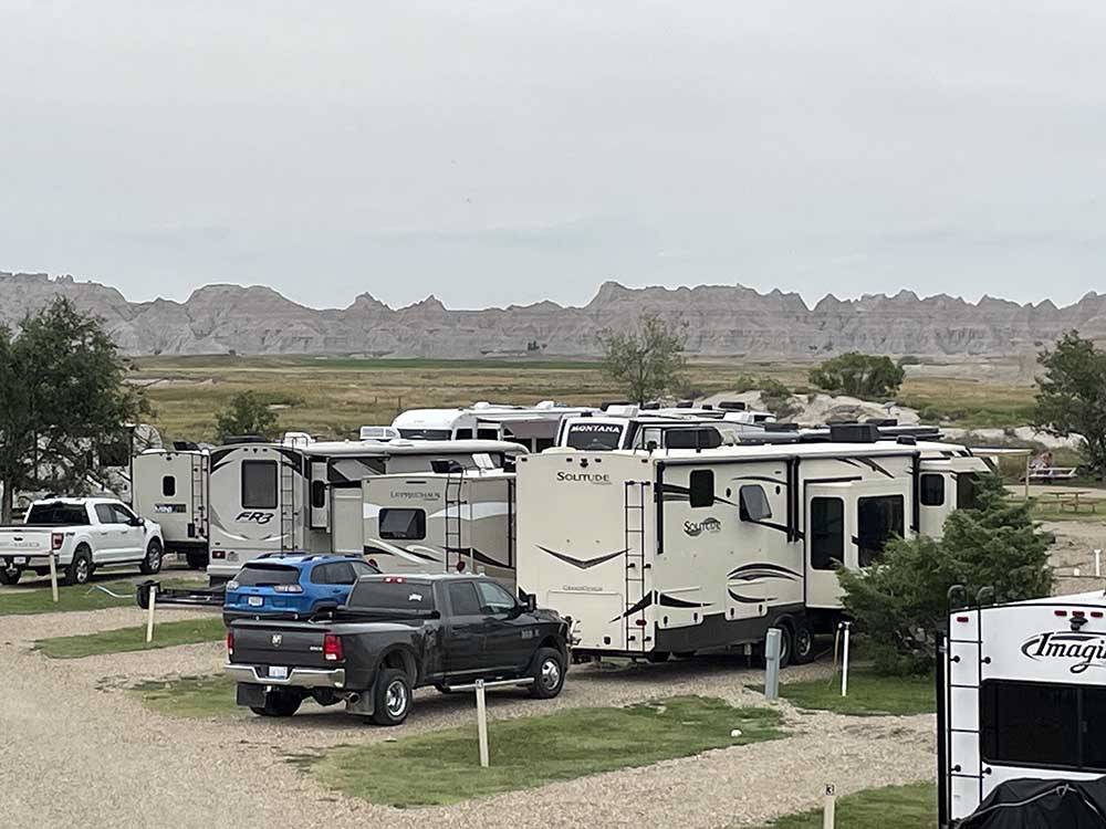 RVs parked on-site with mountains in the distance at BADLANDS MOTEL & CAMPGROUND
