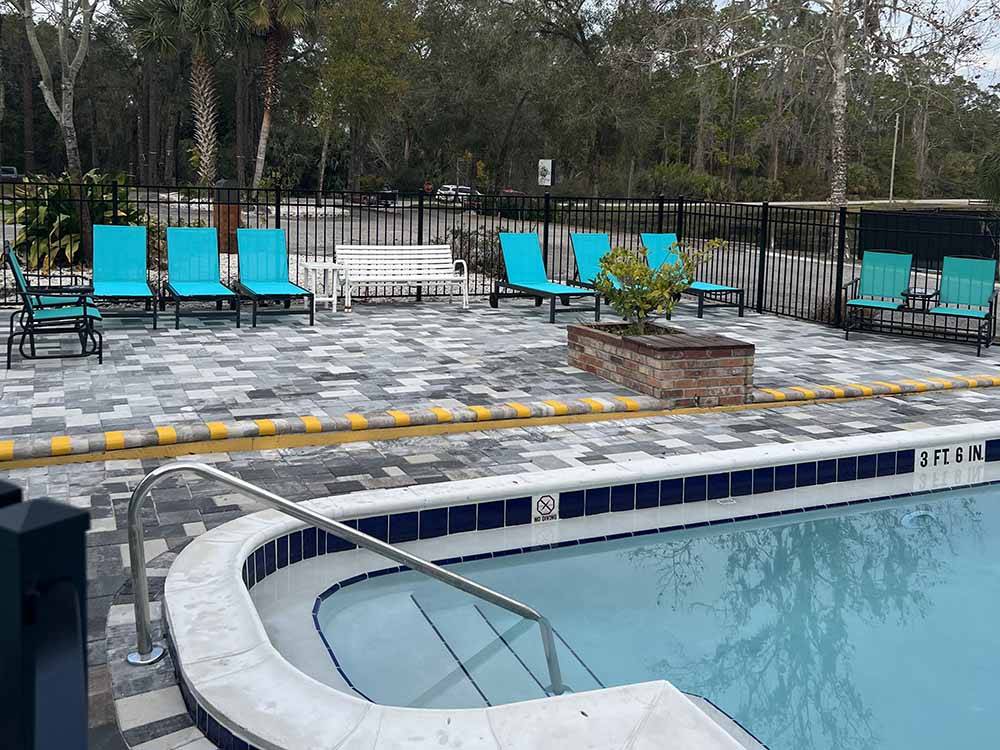 Aqua color lounge chairs by the swimming pool at LUNA SANDS RV RESORT