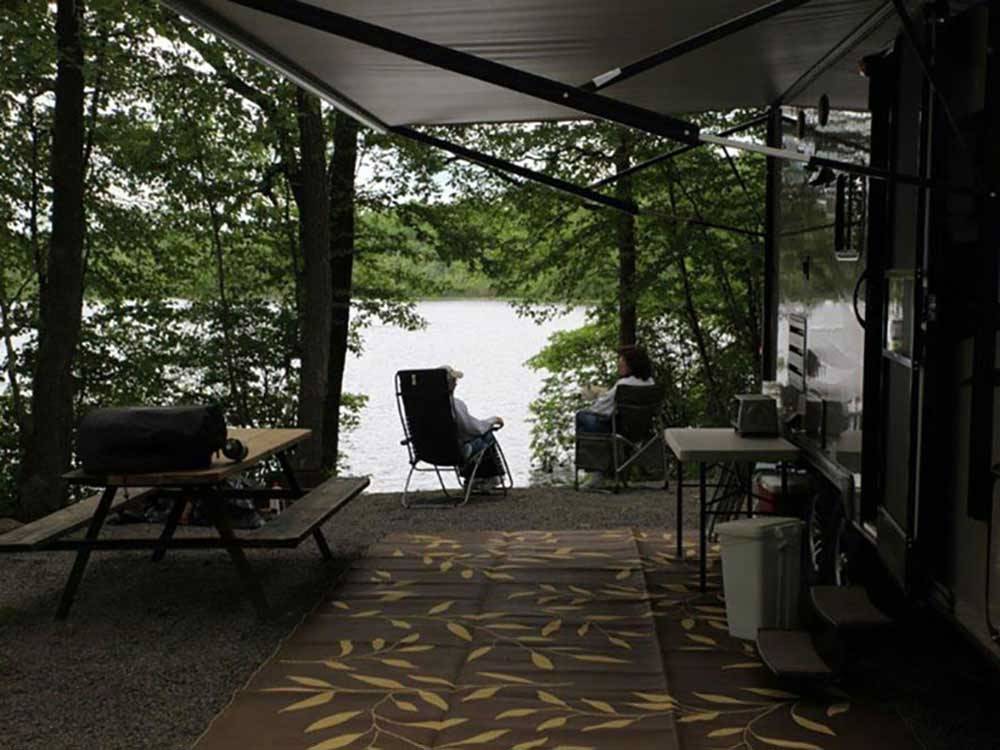 A man relaxing near his campsite at OTTER LAKE CAMP RESORT