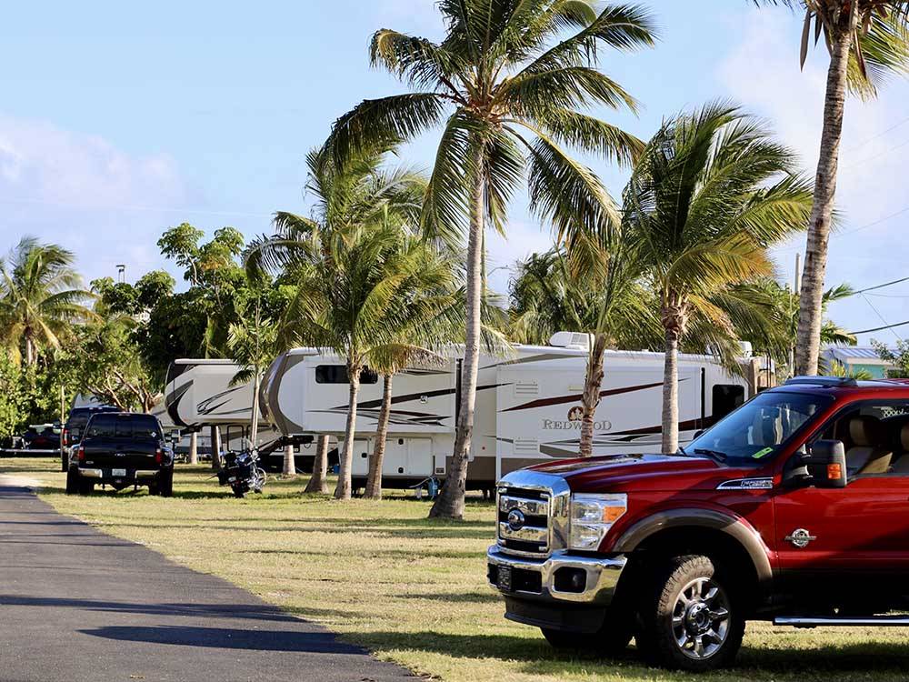 A row of trailers in grassy sites at JOLLY ROGER RV RESORT