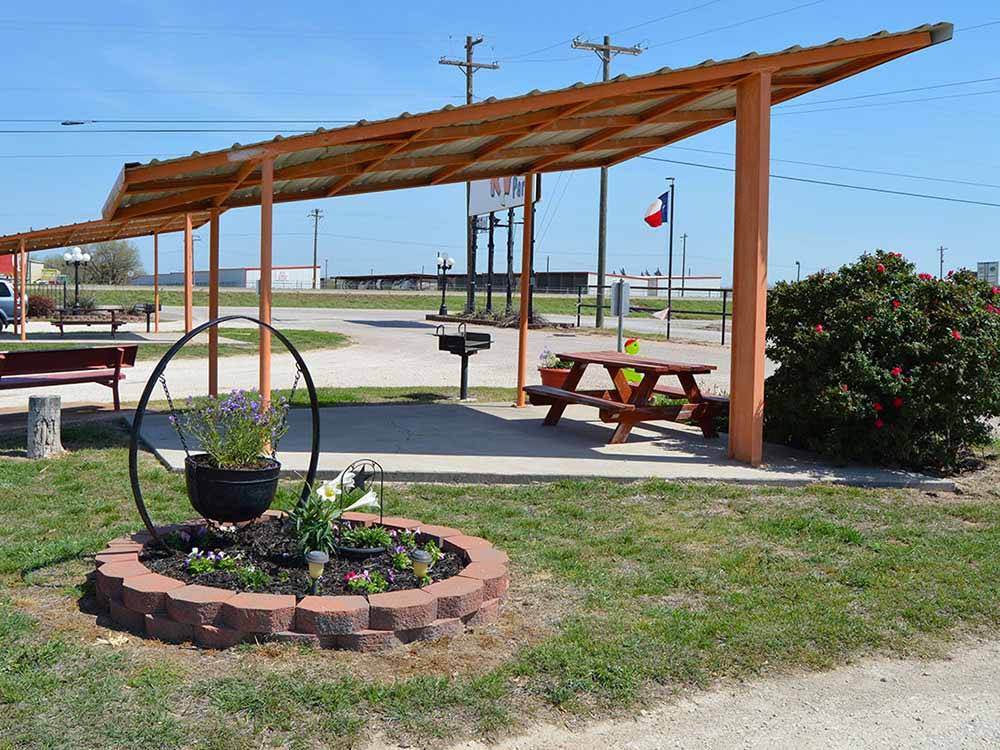 Bench and fire pit under a pavilion at ABILENE RV PARK