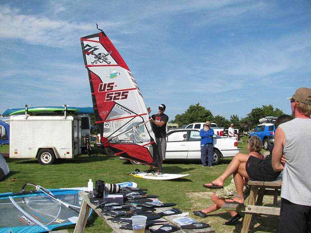 A man setting up a sailboard at FRISCO WOODS CAMPGROUND