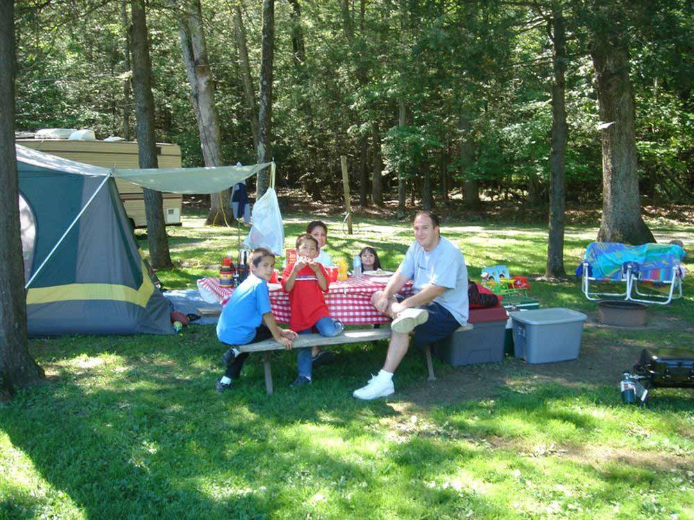 Family camping in tent at FOUR SEASONS CAMPGROUNDS