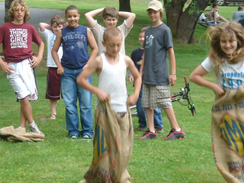 Group of kids in a potato sack race at FOUR SEASONS CAMPGROUNDS
