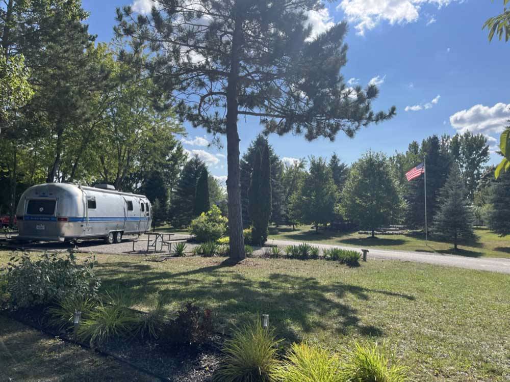 Airstream trailer camping near grassy meadow at HOLIDAY PARK CAMPGROUND