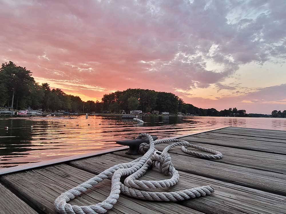 Rope tied to a cleat on a wooden dock overlooking a lake at HOLIDAY PARK CAMPGROUND
