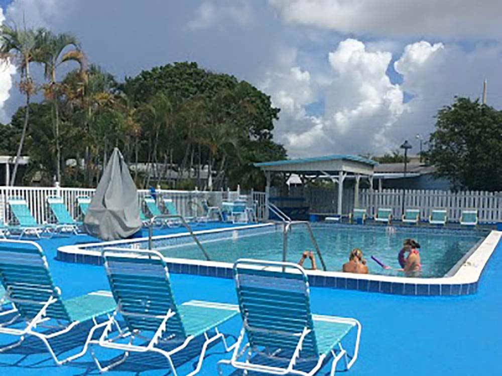 Swimming pool with outdoor seating at PARADISE ISLAND RV RESORT