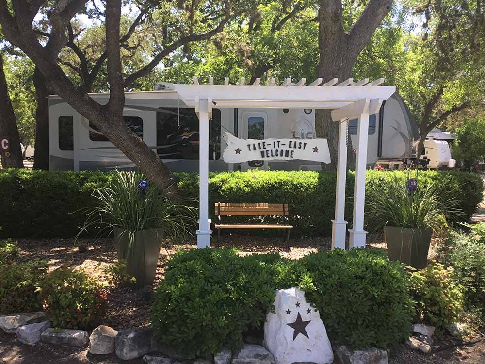 A park bench under a pergola at TAKE-IT-EASY RV RESORT