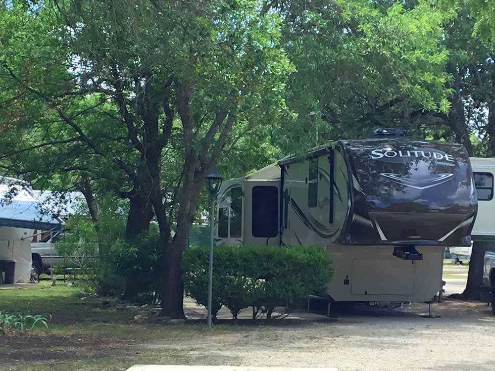 5th wheel parked under shade trees at TAKE-IT-EASY RV RESORT