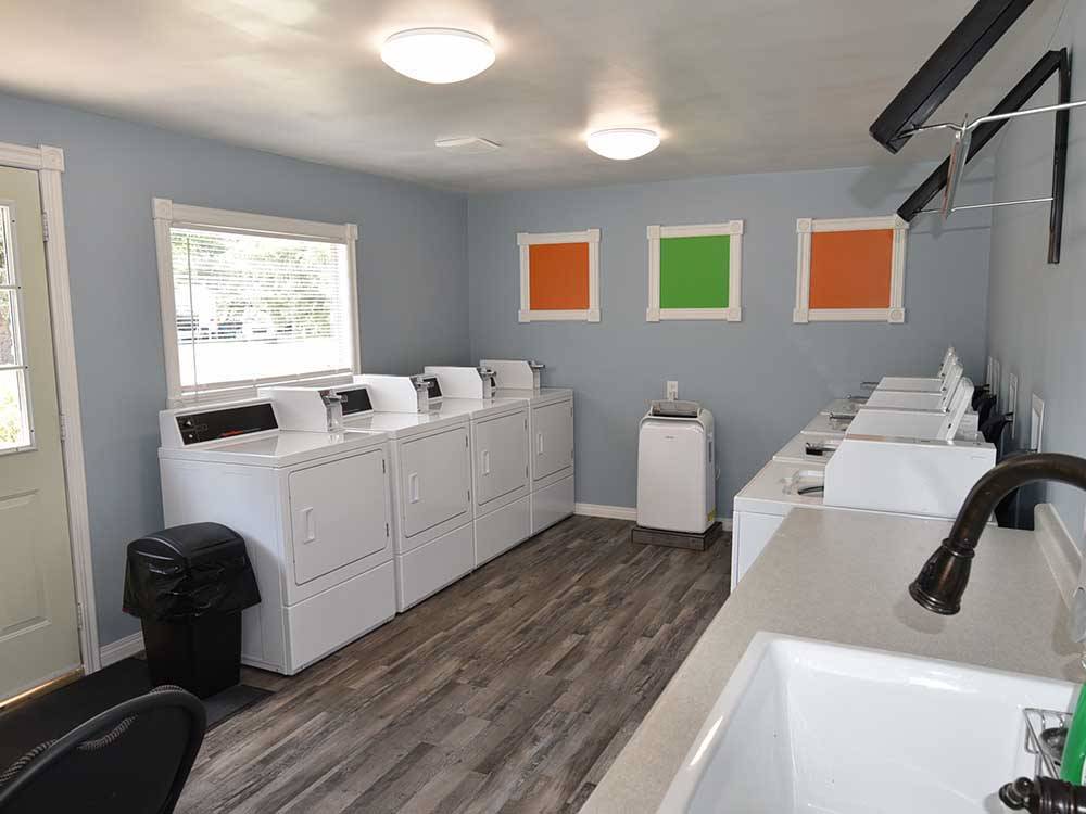 Laundry room with white machines on each side and a wood floor at INDIAN HEAD CAMPGROUND