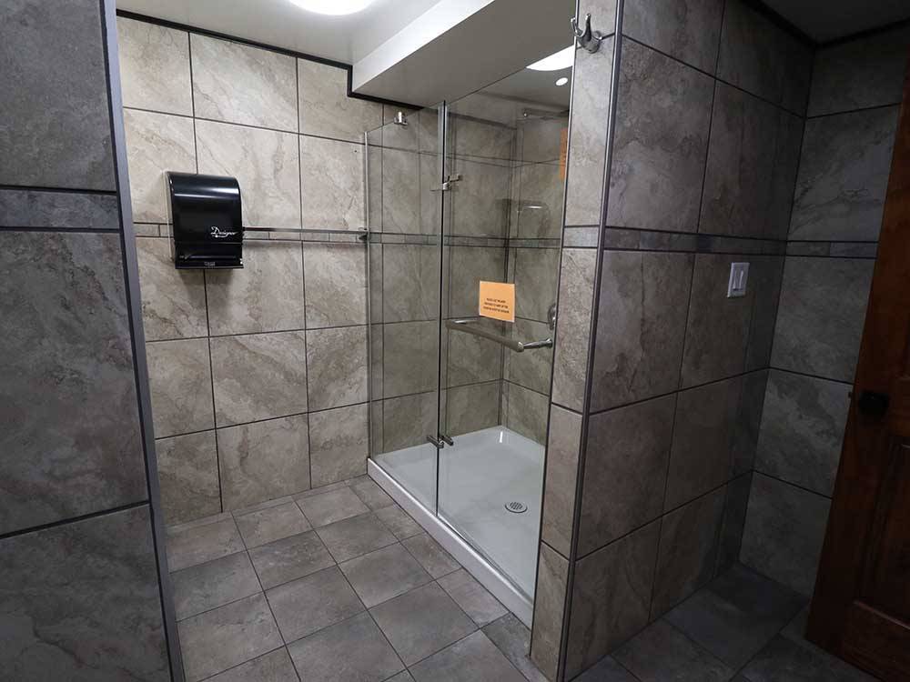 Shower with gray stone walls and glass shower door at INDIAN HEAD CAMPGROUND