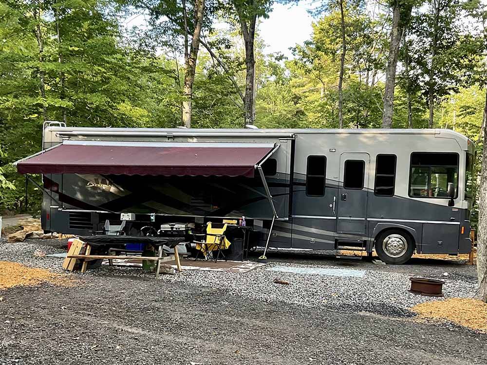 A motorhome in a gravel RV site at AUGUSTA-WEST LAKESIDE KAMPGROUND