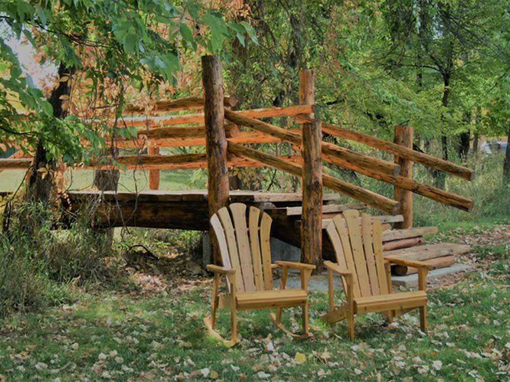 Chairs next to bridge leading to cottages at LAKE PARK CAMPGROUND & COTTAGES