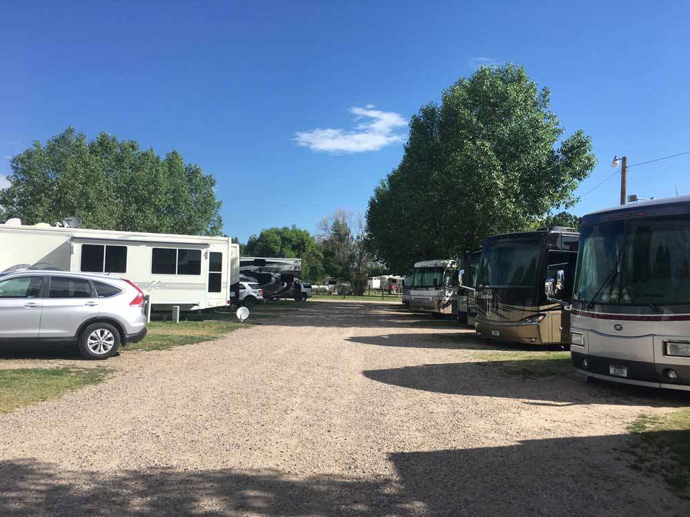 Gravel road lined with big rigs in sites at AB CAMPING RV PARK