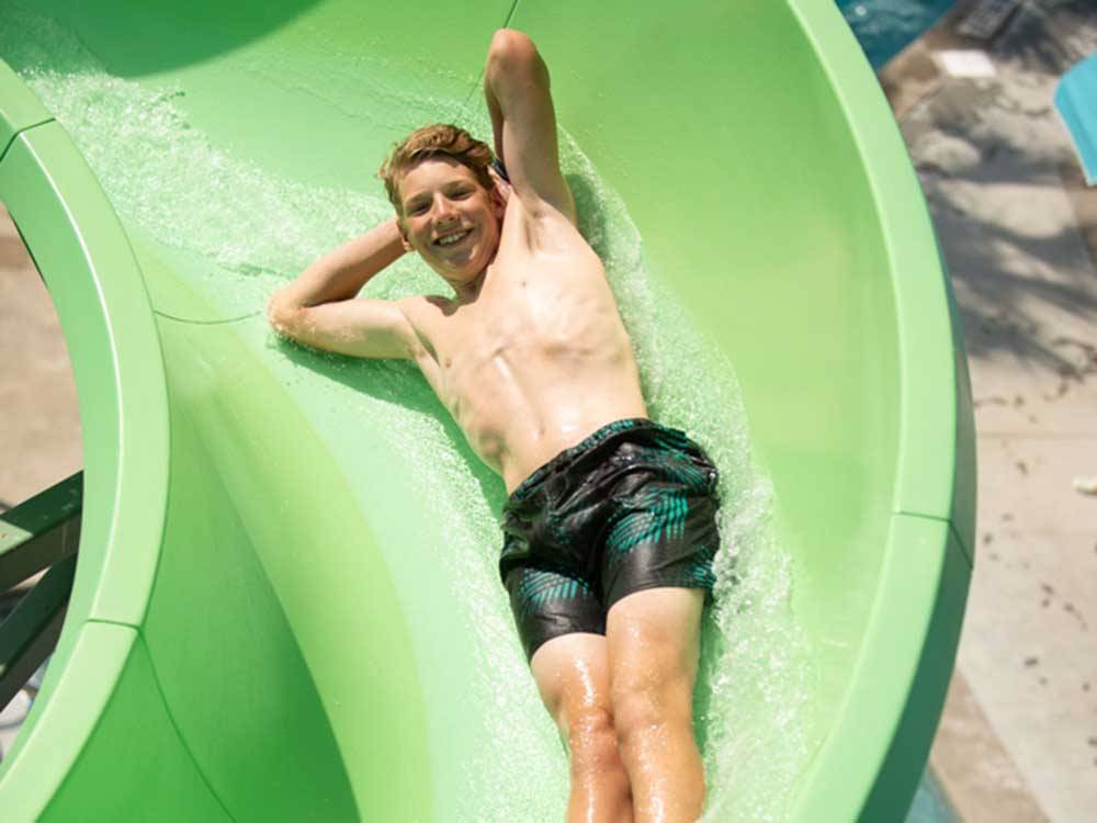 A teenager going down a waterslide at LAKEWOOD CAMPING RESORT