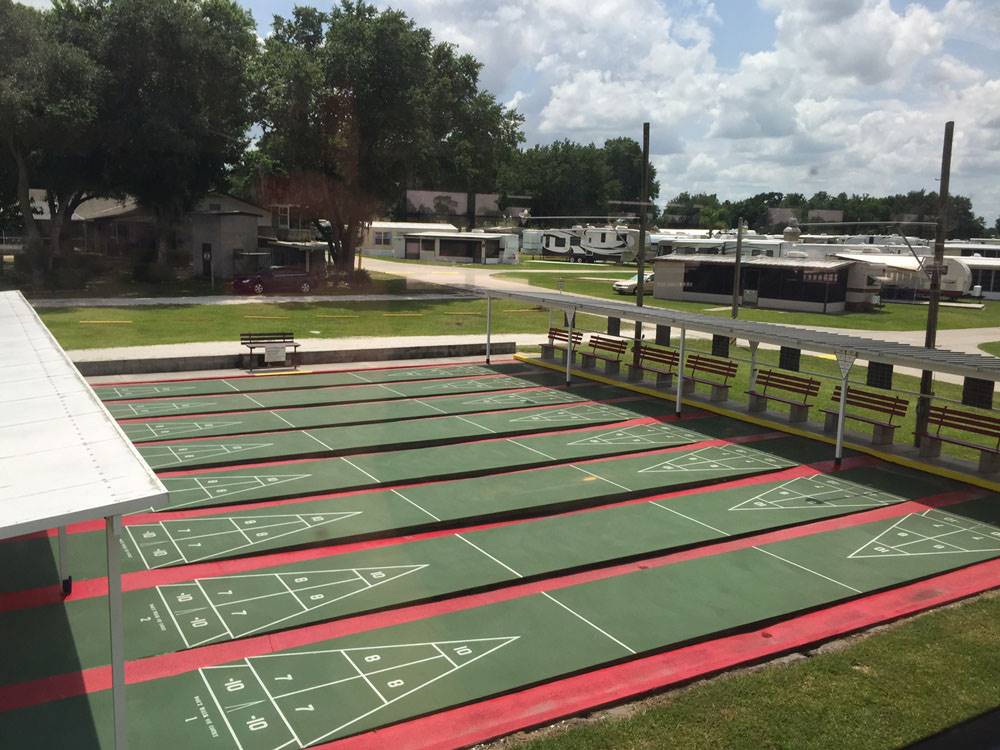 Aerial view of pristine shuffle board courts with RVs in background at CRAIG'S RV PARK