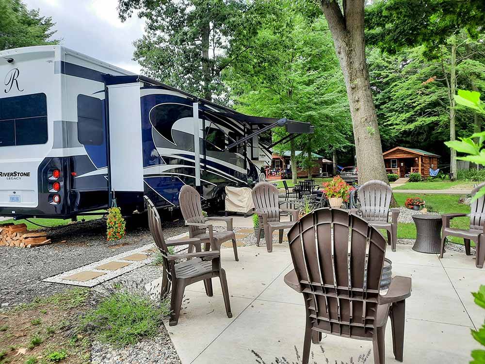 Motorhome parked in site next to chairs and fire pit at HUNGRY HORSE FAMILY CAMPGROUND