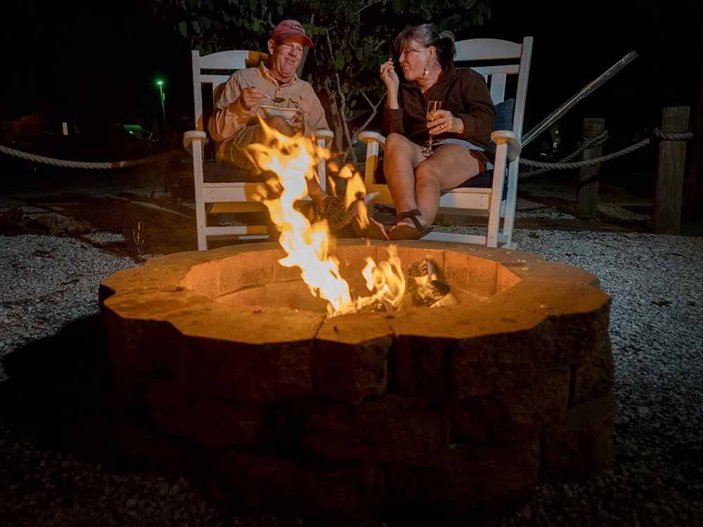 A couple sitting next to a burning fire at CHOKOLOSKEE ISLAND RESORT
