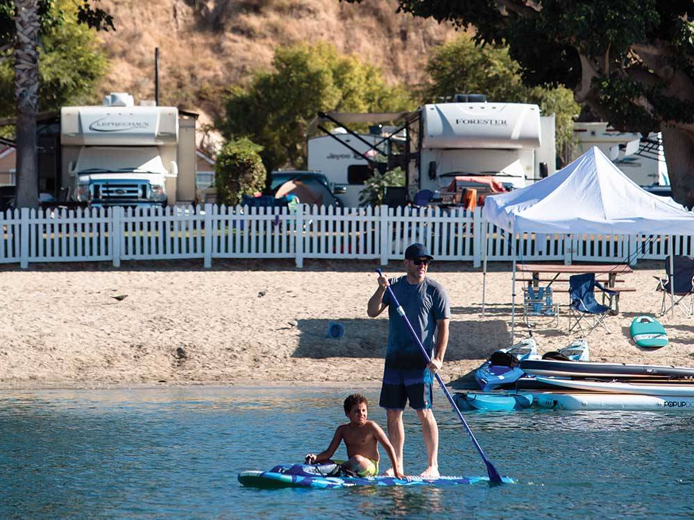 A couple of people paddle boarding at NEWPORT DUNES WATERFRONT RESORT & MARINA