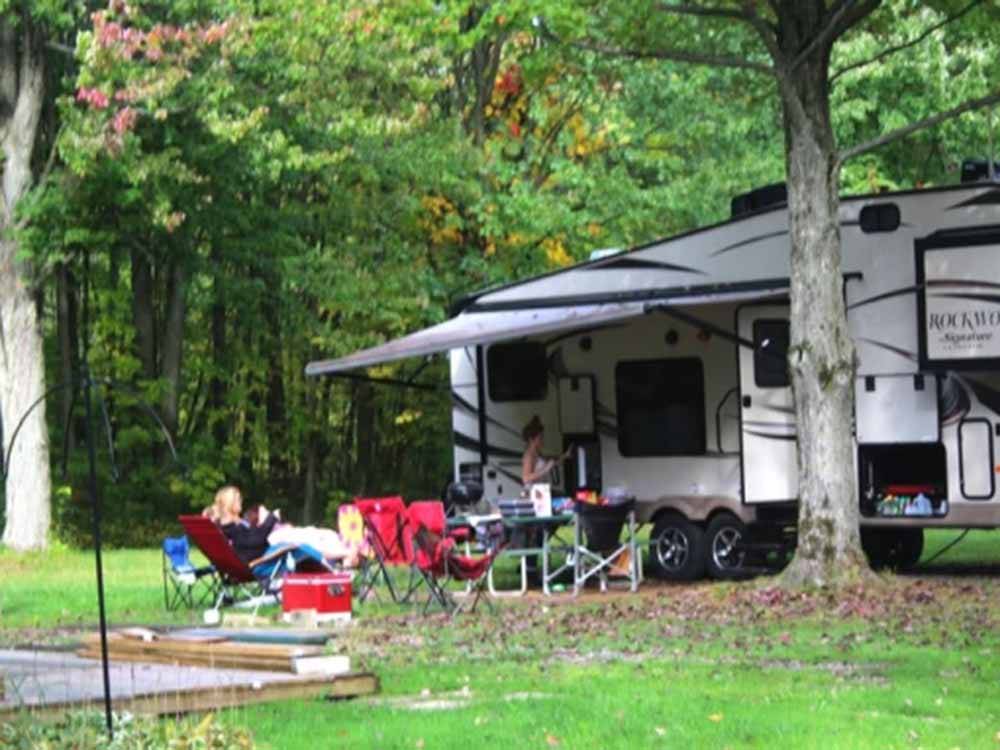 People sitting next to a trailer at CHERRY GROVE CAMPGROUND