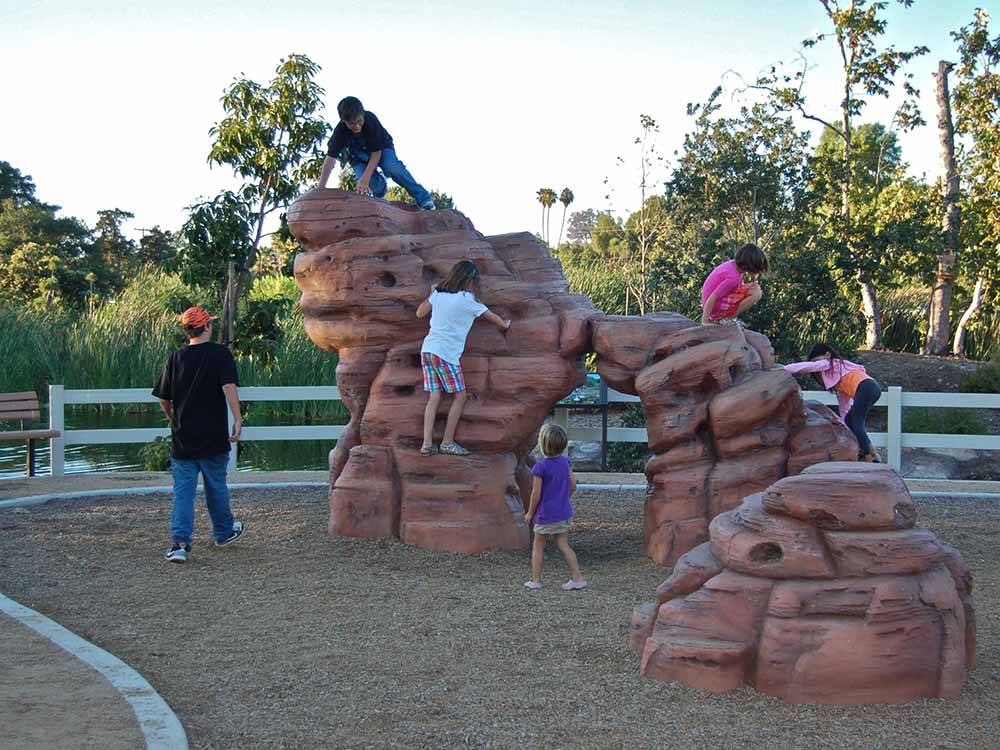 Kids playing on a large man made rock formation at SANTEE LAKES RECREATION PRESERVE