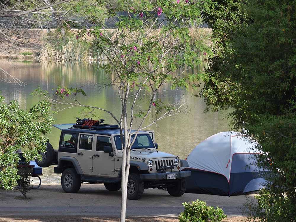 A Jeep with a tent along the water at SANTEE LAKES RECREATION PRESERVE