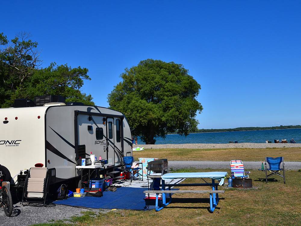 A fifth wheel parked in a gravel site at QUINTE'S ISLE CAMPARK
