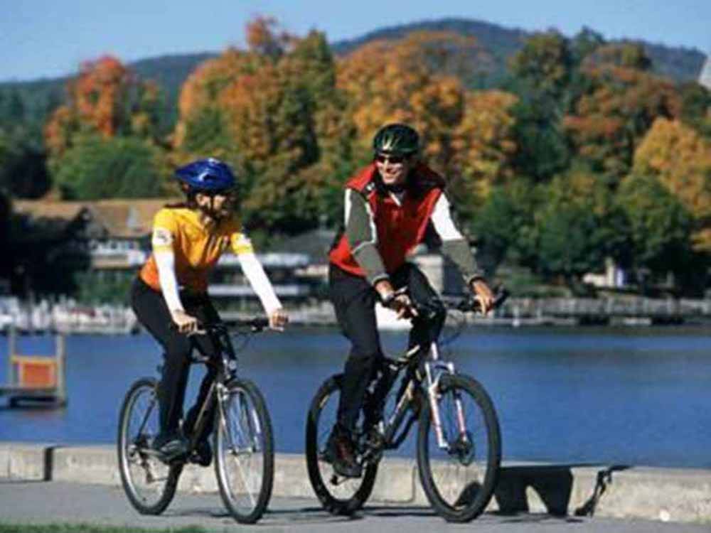 Couple riding bicycles near the water at KING PHILLIPS CAMPGROUND