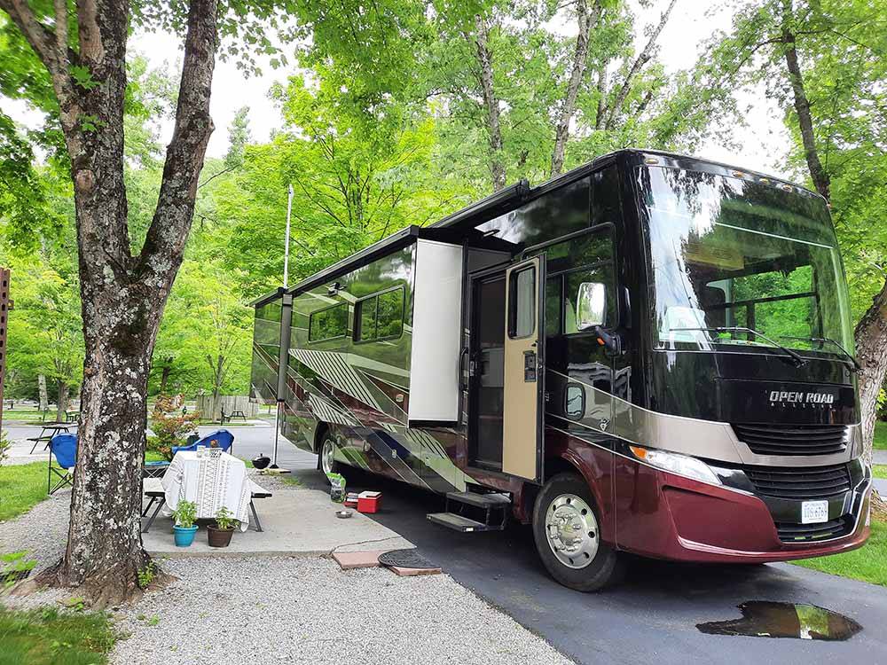 A motorhome in a paved RV site at TWIN CREEK RV RESORT