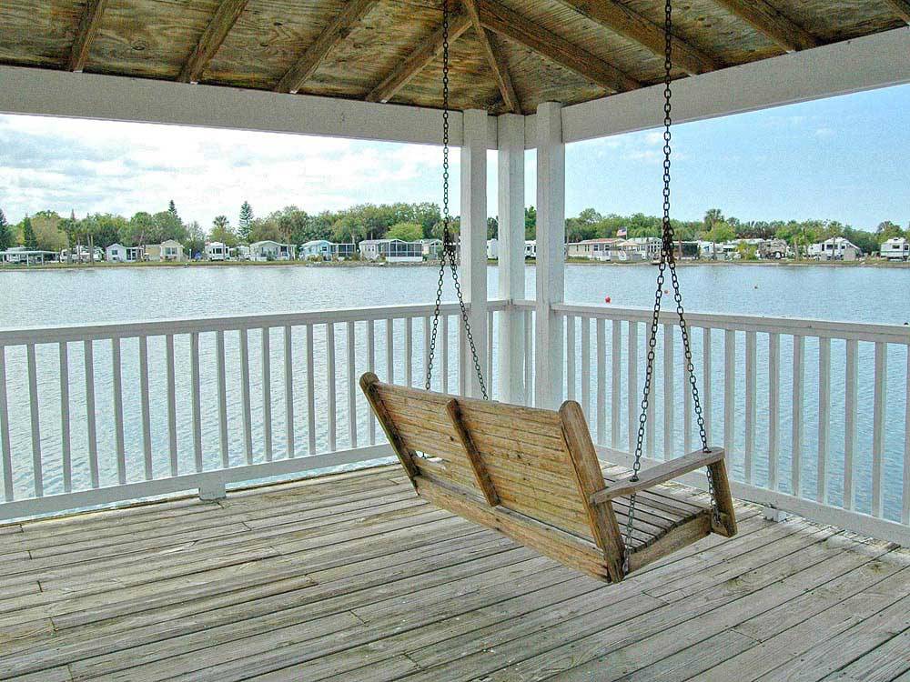 Wooden bench hanging on patio overlooking lake at ENCORE WINTER QUARTERS MANATEE 