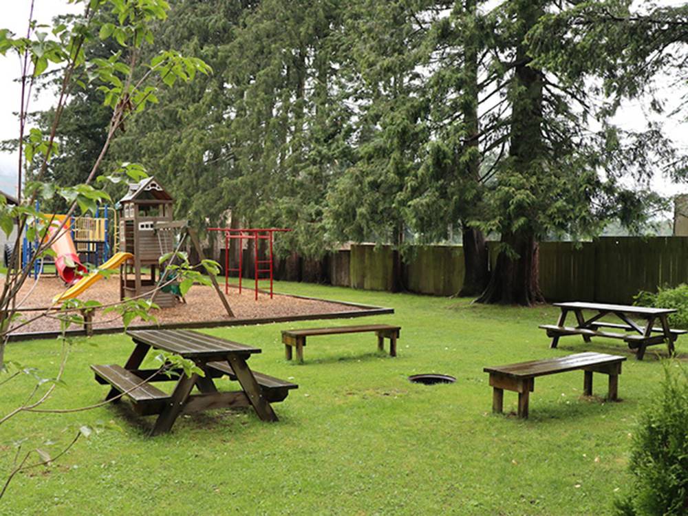 Picnic benches next to the playground at WILD ROSE CAMPGROUND & RV PARK