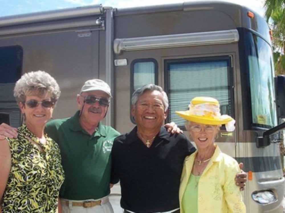 Two couples standing in front of a motorhome at RINCON COUNTRY WEST RV RESORT