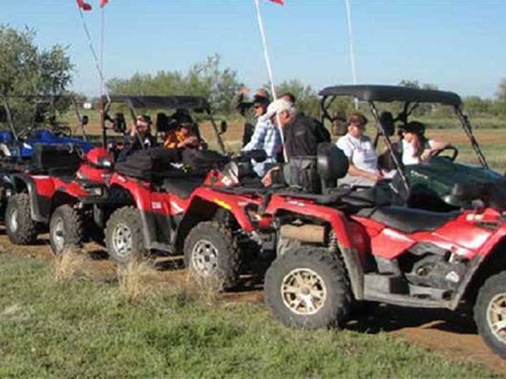 Row of people in red ATVs at ARIZONIAN RV RESORT