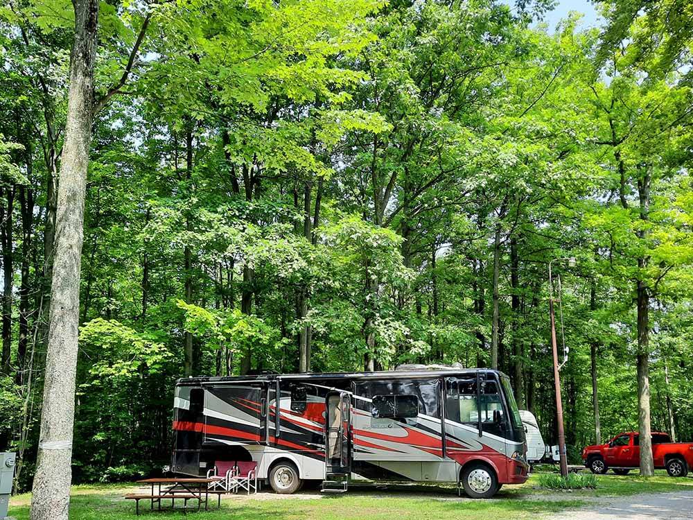A black and red motorhome in a RV site at HIDDEN HILL FAMILY CAMPGROUND