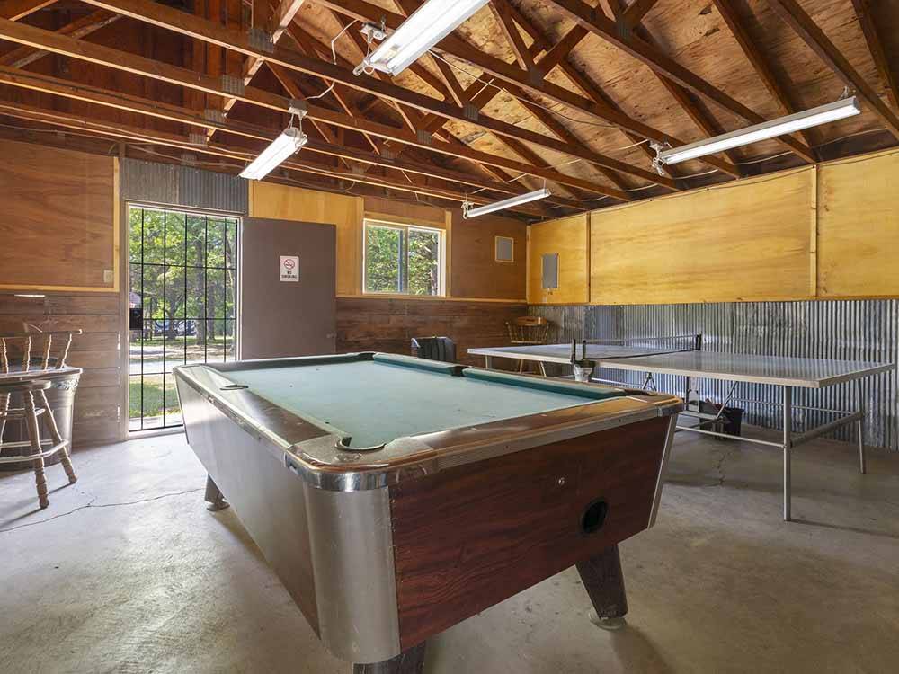 A pool table and ping pong table in the rec room at BAR M RESORT & CAMPGROUND