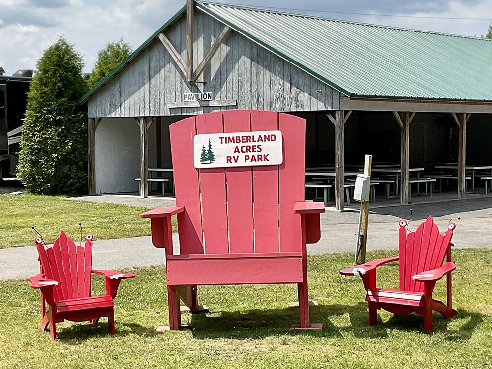 One big red chair and two small red chairs at TIMBERLAND ACRES RV PARK