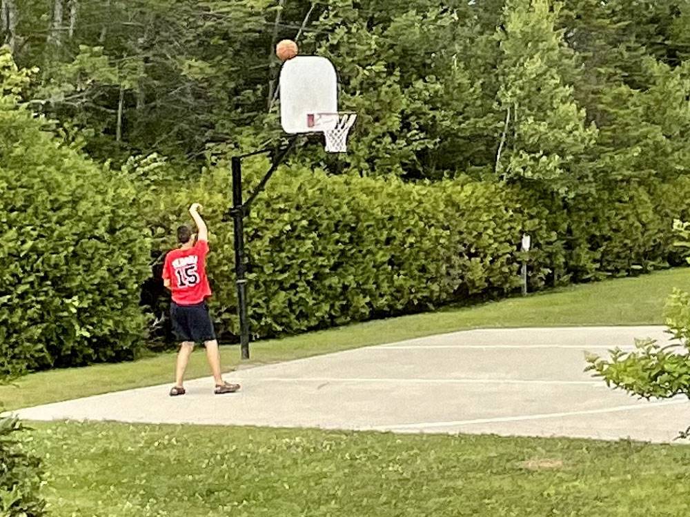 A young man playing basketball at TIMBERLAND ACRES RV PARK
