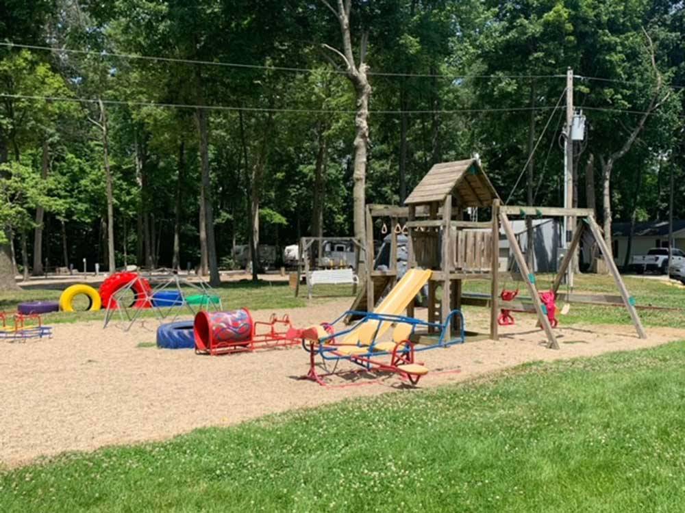 Wooden play structure with slide at CAMP LAKEWOOD CAMPGROUND