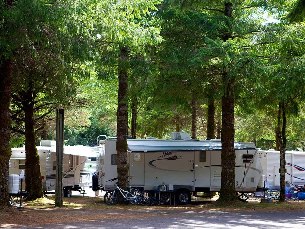A travel trailer under trees at CANNON BEACH RV RESORT