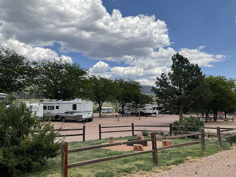 Campground with wood-fenced lawn in middle at ROYAL VIEW RV PARK