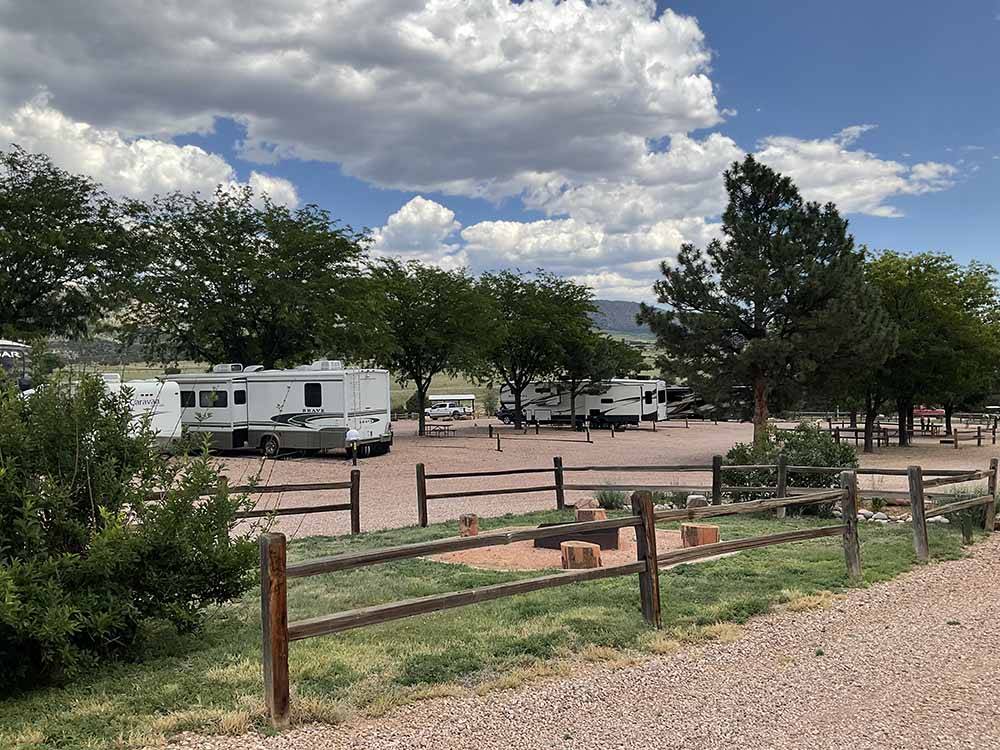 Trees dot a campground with RVs and wooden frences at ROYAL VIEW RV PARK