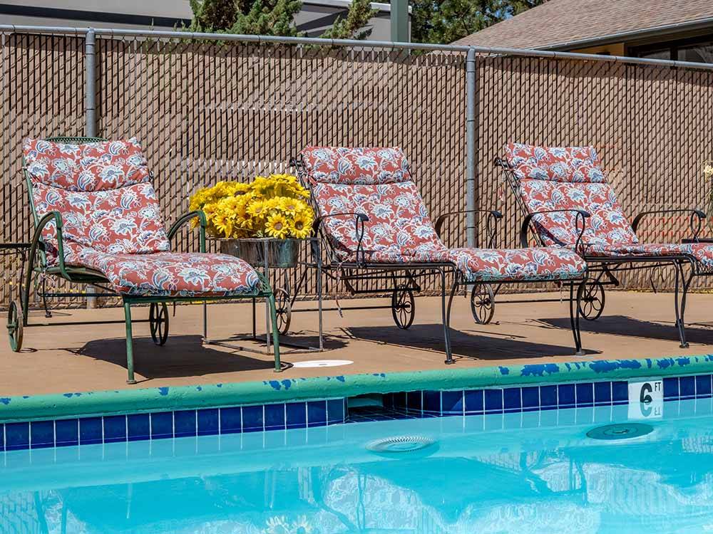 The lounge chairs by the swimming pool at SHAMROCK RV PARK