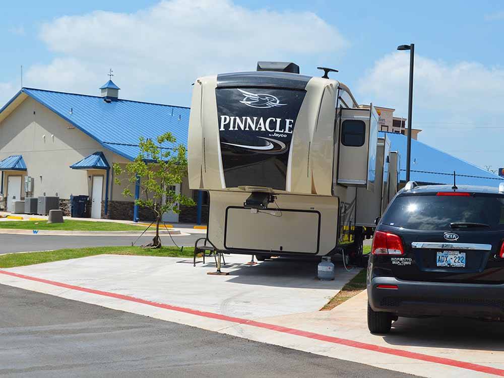 A fifth wheel trailer in a paved RV site at ROADRUNNER RV PARK